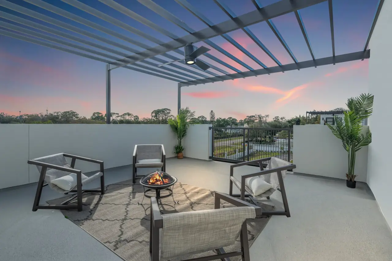 Firepit lit on a rooftop terrace as the sun sets toward the Gulf at Latitudes in the Park, Pinellas Park FL