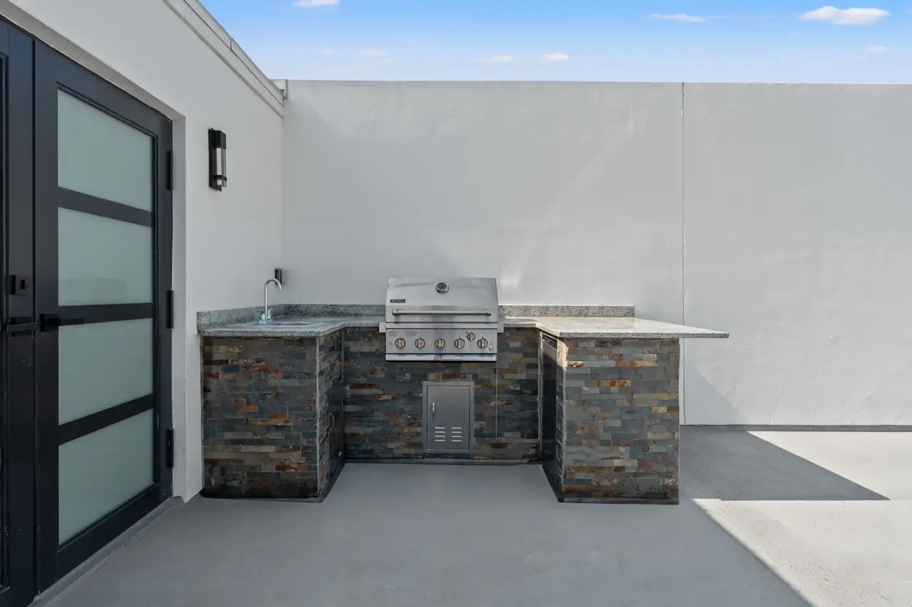 Built-in grill station with stone counter on a premium corner rooftop at Latitudes in the Park, Pinellas Park FL